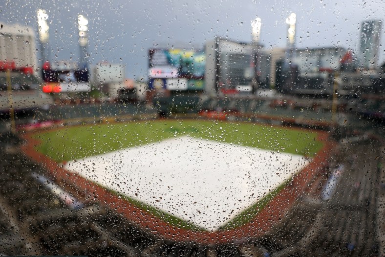 Apr 24, 2021; Atlanta, Georgia, USA; Rain drops are shown on a piece of glass as a tarp is shown on the infield before the start of the game between the Arizona Diamondbacks and the Atlanta Braves at Truist Park. Mandatory Credit: Jason Getz-USA TODAY Sports