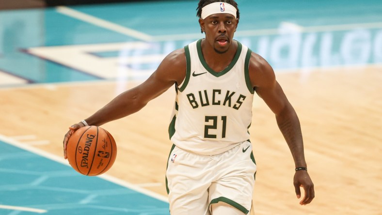 Apr 27, 2021; Charlotte, North Carolina, USA; Milwaukee Bucks guard Jrue Holiday (21) brings the ball up court against the Charlotte Hornets in the second half at Spectrum Center. The Milwaukee Bucks won 114-104. Mandatory Credit: Nell Redmond-USA TODAY Sports