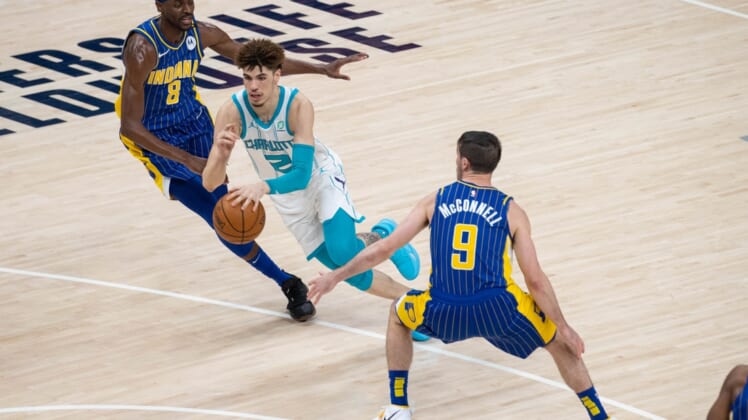 May 18, 2021; Indianapolis, Indiana, USA; Charlotte Hornets guard LaMelo Ball (2) dribbles the ball while Indiana Pacers forward Justin Holiday (8) defends  in the third quarter at Bankers Life Fieldhouse. Mandatory Credit: Trevor Ruszkowski-USA TODAY Sports