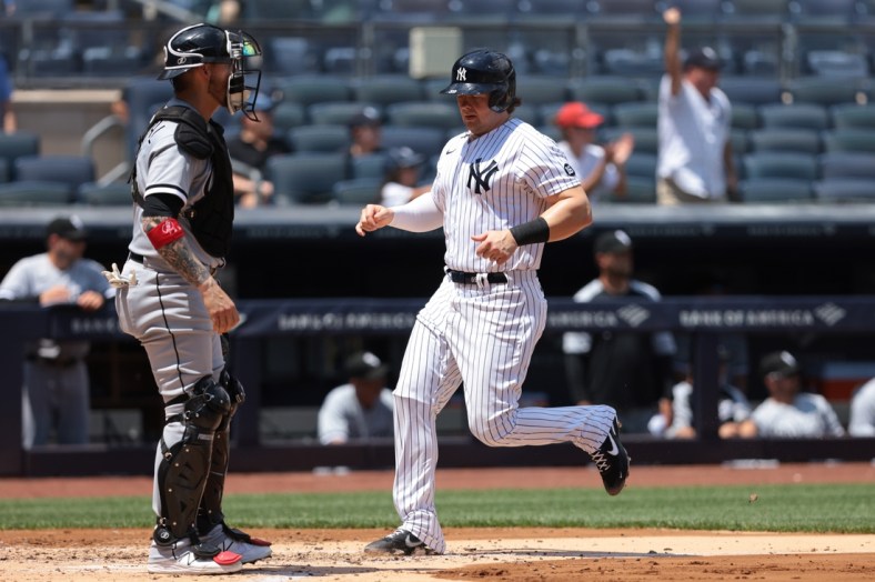 May 23, 2021; Bronx, New York, USA; New York Yankees first baseman Luke Voit (59) scores a run during the first inning in front of Chicago White Sox catcher Yasmani Grandal (24) at Yankee Stadium. Mandatory Credit: Vincent Carchietta-USA TODAY Sports