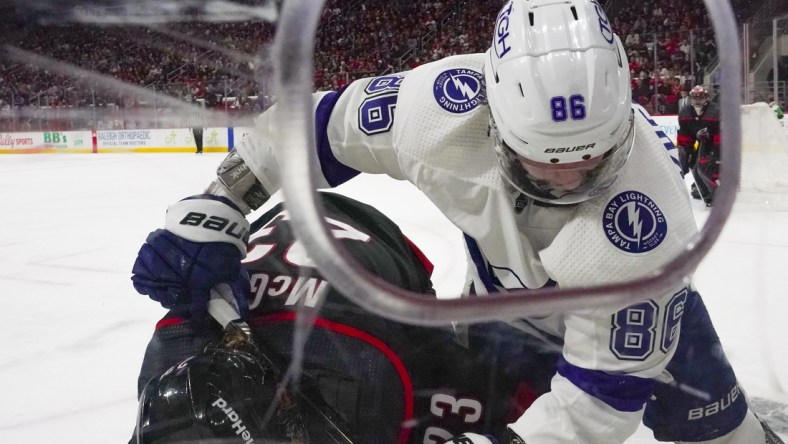 May 30, 2021; Raleigh, North Carolina, USA; Tampa Bay Lightning right wing Nikita Kucherov (86) stick checks Carolina Hurricanes left wing Brock McGinn (23) during the third period in game one of the second round of the 2021 Stanley Cup Playoffs at PNC Arena. Mandatory Credit: James Guillory-USA TODAY Sports