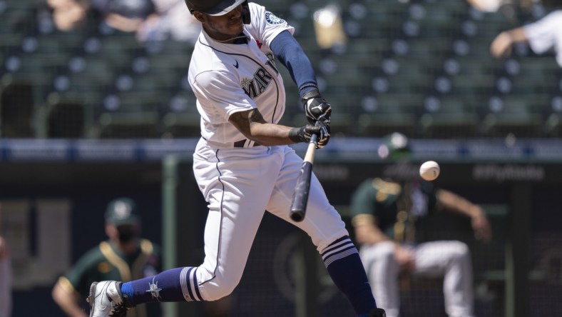 May 31, 2021; Seattle, Washington, USA; Seattle Mariners centerfielder Kyle Lewis (1) hits an RBI-double off of Oakland Athletics starting pitcher James Kaprielian (32) during the fourth inning of a game at T-Mobile Park. Mandatory Credit: Stephen Brashear-USA TODAY Sports