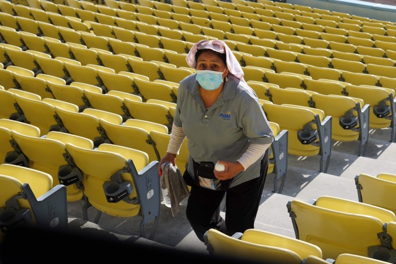Jun 1, 2021; Los Angeles, California, USA; A female worker with a face mask sanitizes surfaces before the game between the Los Angeles Dodgers and the St. Louis Cardinals at Dodger Stadium. Mandatory Credit: Kirby Lee-USA TODAY Sports