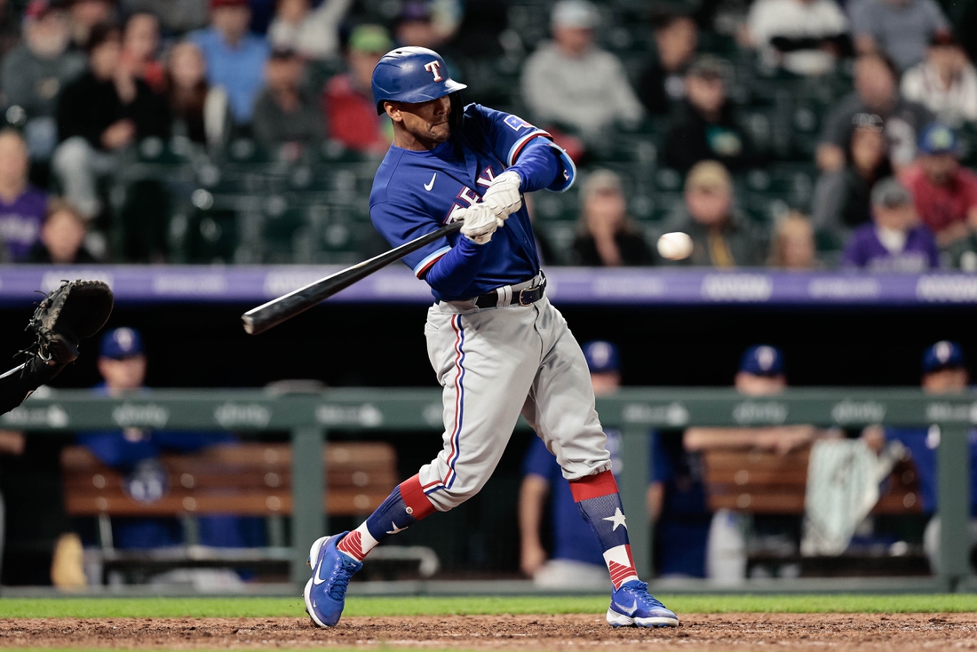 Jun 1, 2021; Denver, Colorado, USA; Texas Rangers pinch hitter Khris Davis (4) hits a solo home run in the eighth inning against the Colorado Rockies at Coors Field. Mandatory Credit: Isaiah J. Downing-USA TODAY Sports