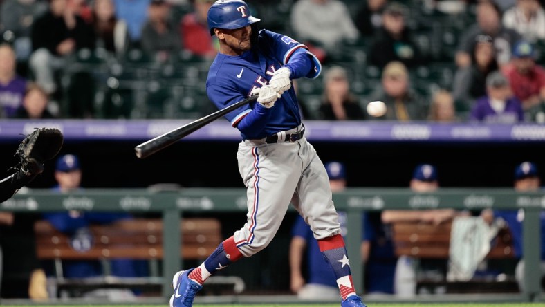 Jun 1, 2021; Denver, Colorado, USA; Texas Rangers pinch hitter Khris Davis (4) hits a solo home run in the eighth inning against the Colorado Rockies at Coors Field. Mandatory Credit: Isaiah J. Downing-USA TODAY Sports