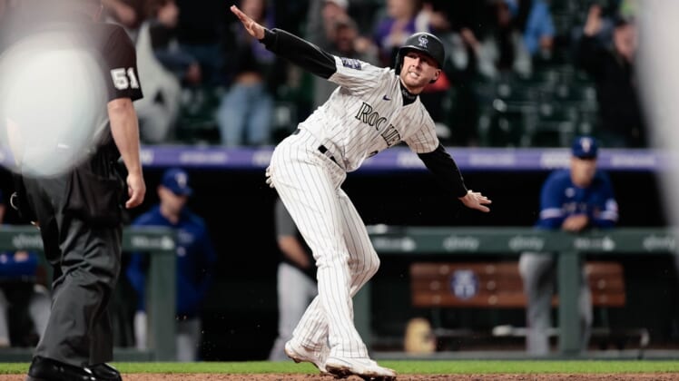 Jun 1, 2021; Denver, Colorado, USA; Colorado Rockies second baseman Ryan McMahon (24) reacts after reaching home on a play in the eleventh inning against the Texas Rangers at Coors Field. Mandatory Credit: Isaiah J. Downing-USA TODAY Sports
