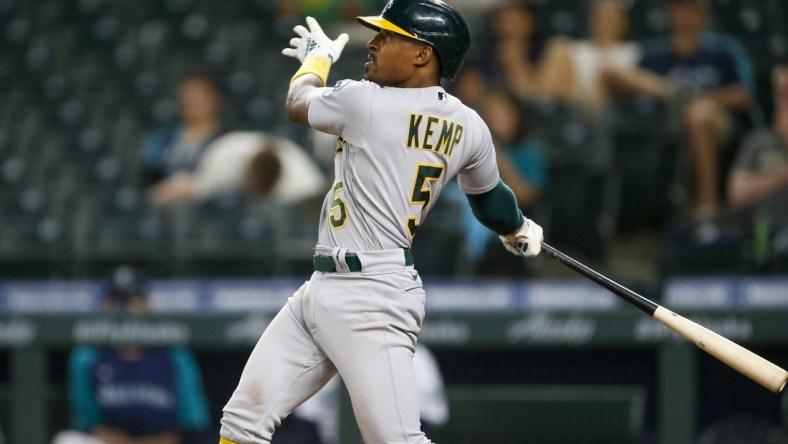 Jun 1, 2021; Seattle, Washington, USA; Oakland Athletics second baseman Tony Kemp (5) hits an RBI-sacrifice fly against the Seattle Mariners during the seventh inning at T-Mobile Park. Mandatory Credit: Joe Nicholson-USA TODAY Sports