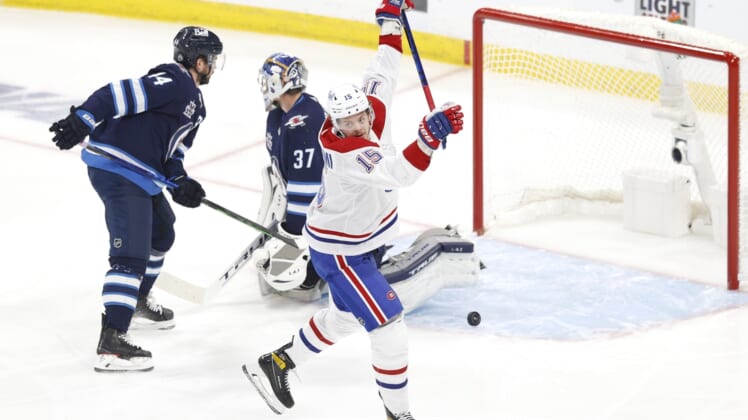 Jun 2, 2021; Winnipeg, Manitoba, CAN; Montreal Canadiens center Jesperi Kotkaniemi (15) scores a first period goal against Winnipeg Jets goaltender Connor Hellebuyck (37) in game one of the second round of the 2021 Stanley Cup Playoffs at Bell MTS Place. Mandatory Credit: James Carey Lauder-USA TODAY Sports