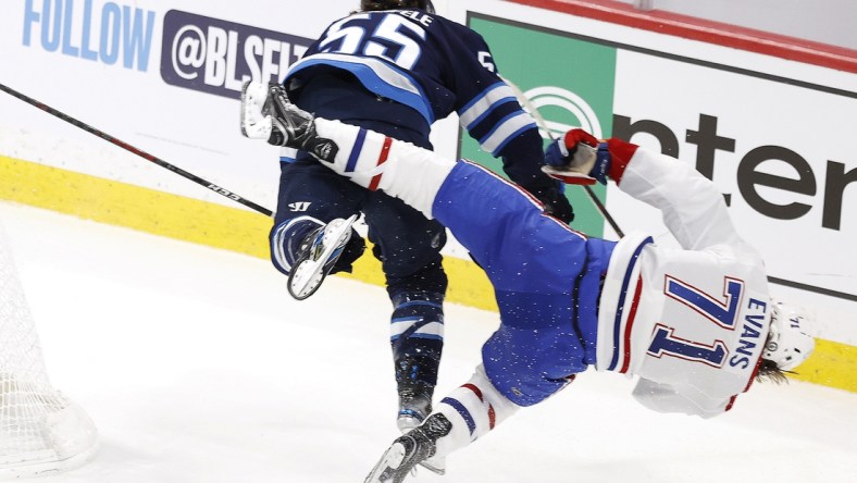 Jun 2, 2021; Winnipeg, Manitoba, CAN; Winnipeg Jets center Mark Scheifele (55) hits Montreal Canadiens center Jake Evans (71) in the third period in game one of the second round of the 2021 Stanley Cup Playoffs at Bell MTS Place. Mandatory Credit: James Carey Lauder-USA TODAY Sports