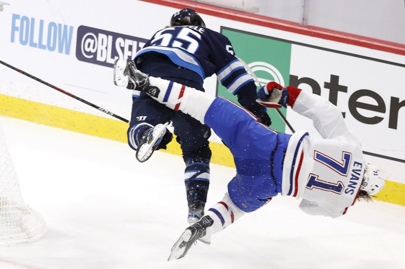 Jun 2, 2021; Winnipeg, Manitoba, CAN; Winnipeg Jets center Mark Scheifele (55) hits Montreal Canadiens center Jake Evans (71) in the third period in game one of the second round of the 2021 Stanley Cup Playoffs at Bell MTS Place. Mandatory Credit: James Carey Lauder-USA TODAY Sports