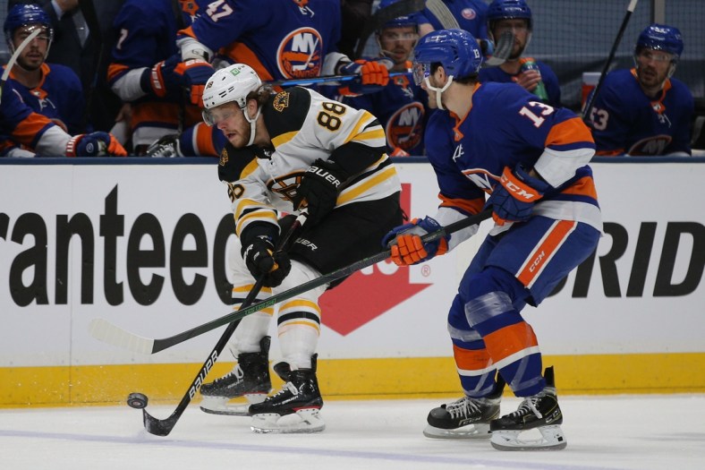 Jun 3, 2021; Uniondale, New York, USA; Boston Bruins right wing David Pastrnak (88) plays the puck against New York Islanders center Mathew Barzal (13) during the first period of game three of the second round of the 2021 Stanley Cup Playoffs at Nassau Veterans Memorial Coliseum. Mandatory Credit: Brad Penner-USA TODAY Sports