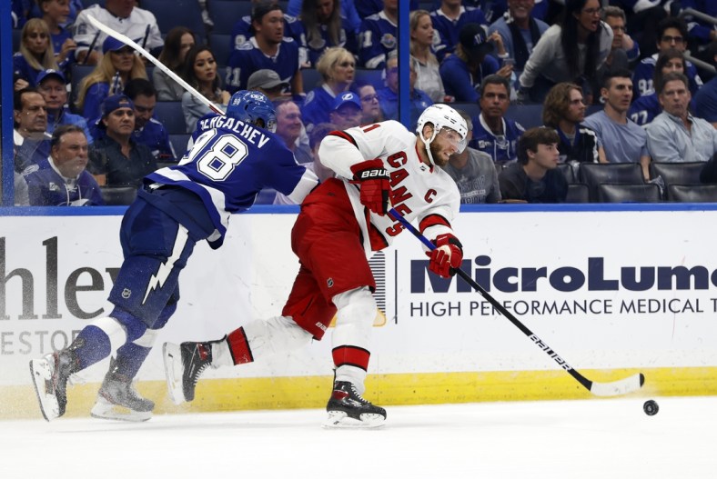 Jun 3, 2021; Tampa, Florida, USA; Carolina Hurricanes center Jordan Staal (11) passes the puck as Tampa Bay Lightning defenseman Mikhail Sergachev (98) defends during the second period in game three of the second round of the 2021 Stanley Cup Playoffs at Amalie Arena. Mandatory Credit: Kim Klement-USA TODAY Sports