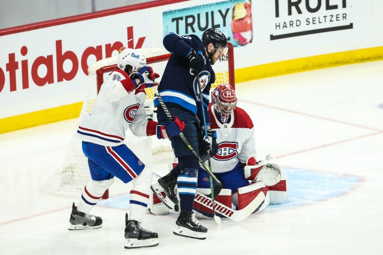Jun 4, 2021; Winnipeg, Manitoba, CAN; Winnipeg Jets forward Pierre-Luc Dubois (13) tries to deflect the puck past Montreal Canadiens goalie Carey Price (31) during the first period in game two of the second round of the 2021 Stanley Cup Playoffs at Bell MTS Place. Mandatory Credit: Terrence Lee-USA TODAY Sports