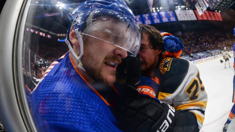 Jun 5, 2021; Uniondale, New York, USA; New York Islanders defenseman Ryan Pulock (left) and Boston Bruins defenseman Connor Clifton (75) fight along the glass during the first period in game four of the second round of the 2021 Stanley Cup Playoffs at Nassau Veterans Memorial Coliseum. Mandatory Credit: Dennis Schneidler-USA TODAY Sports