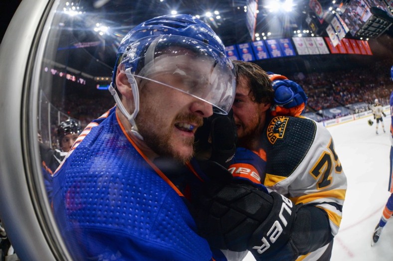 Jun 5, 2021; Uniondale, New York, USA; New York Islanders defenseman Ryan Pulock (left) and Boston Bruins defenseman Connor Clifton (75) fight along the glass during the first period in game four of the second round of the 2021 Stanley Cup Playoffs at Nassau Veterans Memorial Coliseum. Mandatory Credit: Dennis Schneidler-USA TODAY Sports