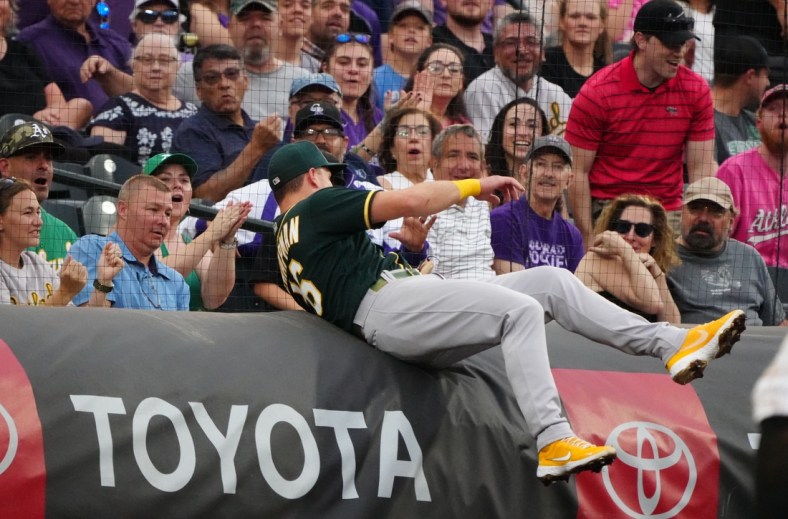 Jun 5, 2021; Denver, Colorado, USA; Oakland Athletics third baseman Matt Chapman (26) attempts to field a foul ball in the first inning against the Colorado Rockies at Coors Field. Mandatory Credit: Ron Chenoy-USA TODAY Sports
