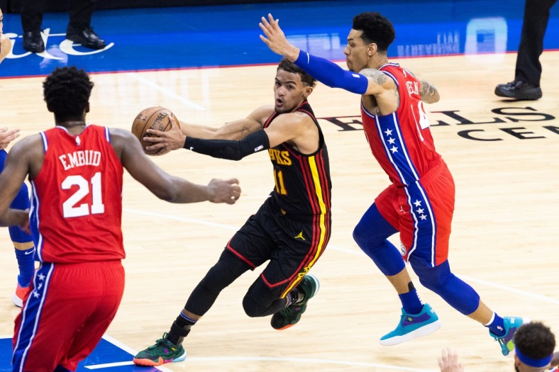 Jun 6, 2021; Philadelphia, Pennsylvania, USA; Atlanta Hawks guard Trae Young (11) drives against Philadelphia 76ers forward Danny Green (14) and center Joel Embiid (21) during the third quarter of game one in the second round of the 2021 NBA Playoffs at Wells Fargo Center. Mandatory Credit: Bill Streicher-USA TODAY Sports