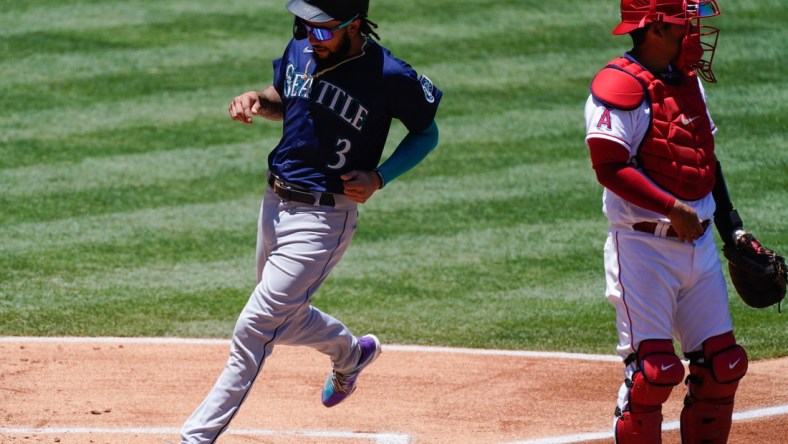 Jun 6, 2021; Anaheim, California, USA; Seattle Mariners shortstop J.P. Crawford (3) scores in the first inning on a sacrifice fly by Kyle Seager (not pictured) at Angel Stadium. Right is Los Angeles Angels catcher Kurt Suzuki (24). Mandatory Credit: Robert Hanashiro-USA TODAY Sports