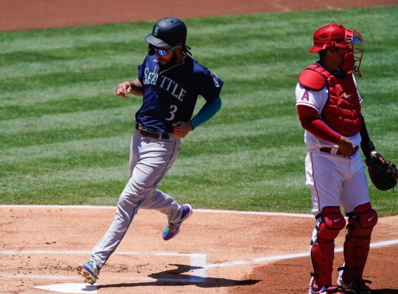 Jun 6, 2021; Anaheim, California, USA; Seattle Mariners shortstop J.P. Crawford (3) scores in the first inning on a sacrifice fly by Kyle Seager (not pictured) at Angel Stadium. Right is Los Angeles Angels catcher Kurt Suzuki (24). Mandatory Credit: Robert Hanashiro-USA TODAY Sports