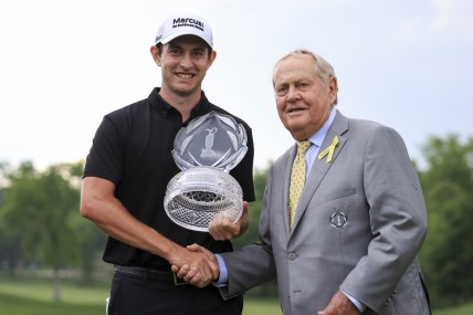Jun 6, 2021; Dublin, Ohio, USA; Patrick Cantlay (left) holds the trophy as he shakes hands with Jack Nicklaus with after winning the Memorial Tournament golf tourney. Mandatory Credit: Aaron Doster-USA TODAY Sports