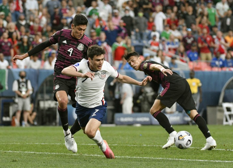 Jun 6, 2021; Denver, Colorado, USA;  United States forward Gio Reyna (7) trips up going after the ball as Mexico midfielder Edson Alvarez (4) defends on the play in the first half during the 2021 CONCACAF Nations League Finals soccer series final match at Empower Field at Mile High. Mandatory Credit: John Leyba-USA TODAY Sports