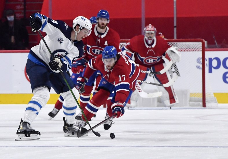 Jun 7, 2021; Montreal, Quebec, CAN; Winnipeg Jets defenseman Logan Stanley (64) plays the puck and Montreal Canadiens forward Josh Anderson (17) defends during the second period in game four of the second round of the 2021 Stanley Cup Playoffs at the Bell Centre. Mandatory Credit: Eric Bolte-USA TODAY Sports