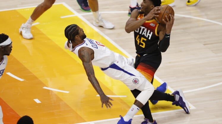 Jun 8, 2021; Salt Lake City, Utah, USA; Utah Jazz guard Donovan Mitchell (45) drives into LA Clippers guard Paul George (13) drawing the foul in the first quarter during game one in the second round of the 2021 NBA Playoffs. at Vivint Arena. Mandatory Credit: Jeffrey Swinger-USA TODAY Sports