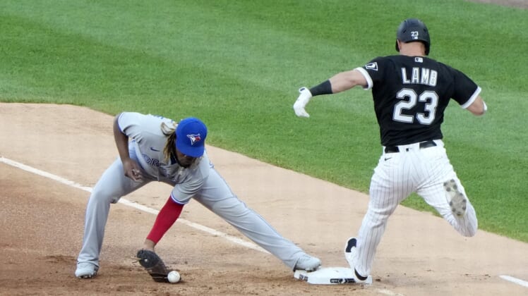 Jun 9, 2021; Chicago, Illinois, USA; Toronto Blue Jays designated hitter Vladimir Guerrero Jr. (27) drops the ball making Chicago White Sox third baseman Jake Lamb (23) safe at first on an error during the first inning at Guaranteed Rate Field. Mandatory Credit: Mike Dinovo-USA TODAY Sports