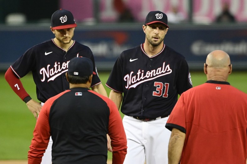 Jun 11, 2021; Washington, District of Columbia, USA;  Washington Nationals starting pitcher Max Scherzer (31) stands on the pitcher's mound as manager Dave Martinez (4) and the team trainer approach during the first inning against the San Francisco Giants at Nationals Park. Mandatory Credit: Tommy Gilligan-USA TODAY Sports