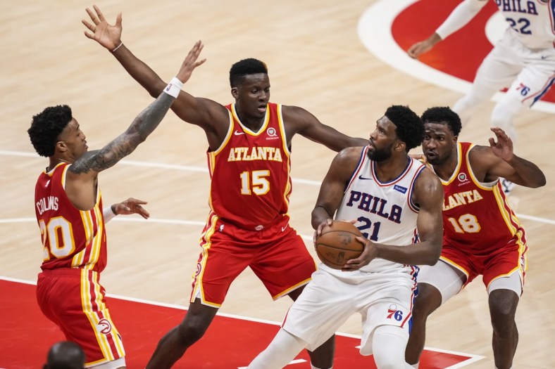 Jun 11, 2021; Atlanta, Georgia, USA; Philadelphia 76ers center Joel Embiid (21) is guarded by Atlanta Hawks forward John Collins (20) center Clint Capela (15) and forward Solomon Hill (18) during the first half of game three in the second round of the 2021 NBA Playoffs at State Farm Arena. Mandatory Credit: Dale Zanine-USA TODAY Sports