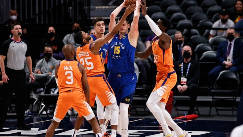 Jun 11, 2021; Denver, Colorado, USA; Denver Nuggets center Nikola Jokic (15) is defended by Phoenix Suns center Deandre Ayton (22) and forward Mikal Bridges (25) as guard Chris Paul (3) and forward Michael Porter Jr. (1) look on in the first quarter during game three in the second round of the 2021 NBA Playoffs at Ball Arena. Mandatory Credit: Isaiah J. Downing-USA TODAY Sports