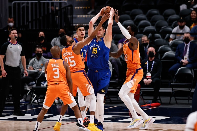 Jun 11, 2021; Denver, Colorado, USA; Denver Nuggets center Nikola Jokic (15) is defended by Phoenix Suns center Deandre Ayton (22) and forward Mikal Bridges (25) as guard Chris Paul (3) and forward Michael Porter Jr. (1) look on in the first quarter during game three in the second round of the 2021 NBA Playoffs at Ball Arena. Mandatory Credit: Isaiah J. Downing-USA TODAY Sports