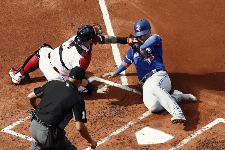 Jun 12, 2021; Boston, Massachusetts, USA; Boston Red Sox catcher Christian Vazquez (7) tags out Toronto Blue Jays second baseman Joe Panik (right) at home plate during the second inning at Fenway Park. Mandatory Credit: Winslow Townson-USA TODAY Sports