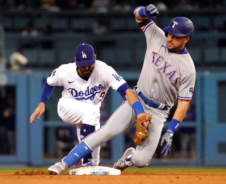 Jun 12, 2021; Los Angeles, California, USA; Texas Rangers first baseman Nate Lowe (30) is tagged out by Los Angeles Dodgers left fielder Chris Taylor (3) after sliding past the base in the third inning at Dodger Stadium. Mandatory Credit: Robert Hanashiro-USA TODAY Sports