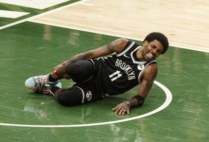 Jun 13, 2021; Milwaukee, Wisconsin, USA;  Brooklyn Nets guard Kyrie Irving (11) grabs his leg after being injured during the second quarter against the Milwaukee Bucks during game four in the second round of the 2021 NBA Playoffs. at Fiserv Forum. Mandatory Credit: Jeff Hanisch-USA TODAY Sports