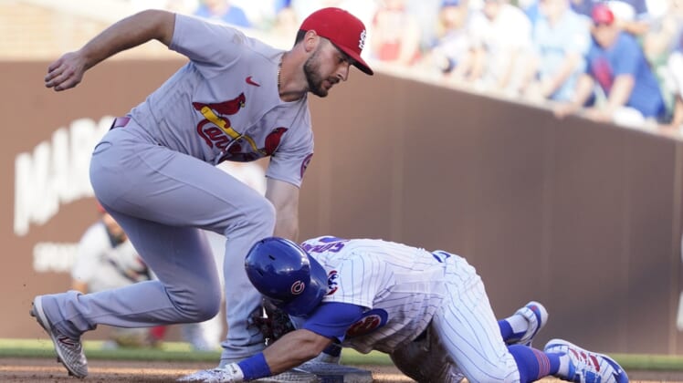 Jun 13, 2021; Chicago, Illinois, USA; Chicago Cubs second baseman Eric Sogard (4) is safe at second base with a double as St. Louis Cardinals shortstop Paul DeJong (11) makes a late tag during the third inning at Wrigley Field. Mandatory Credit: David Banks-USA TODAY Sports