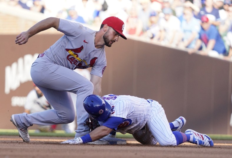 Jun 13, 2021; Chicago, Illinois, USA; Chicago Cubs second baseman Eric Sogard (4) is safe at second base with a double as St. Louis Cardinals shortstop Paul DeJong (11) makes a late tag during the third inning at Wrigley Field. Mandatory Credit: David Banks-USA TODAY Sports