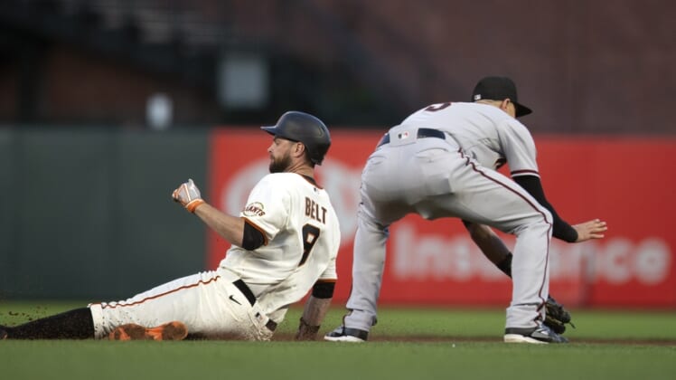Jun 14, 2021; San Francisco, California, USA; San Francisco Giants first baseman Brandon Belt (9) slides safely into second base with a double ahead of the relay to  Arizona Diamondbacks shortstop Nick Ahmed (13) during the fifth inning at Oracle Park. Mandatory Credit: D. Ross Cameron-USA TODAY Sports