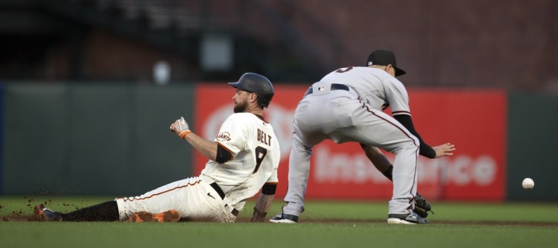 Jun 14, 2021; San Francisco, California, USA; San Francisco Giants first baseman Brandon Belt (9) slides safely into second base with a double ahead of the relay to  Arizona Diamondbacks shortstop Nick Ahmed (13) during the fifth inning at Oracle Park. Mandatory Credit: D. Ross Cameron-USA TODAY Sports