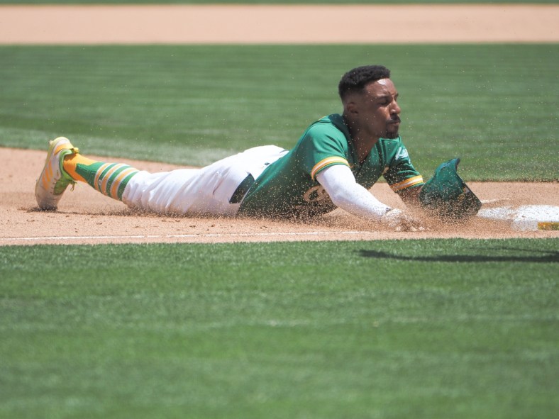 Jun 16, 2021; Oakland, California, USA; Oakland Athletics second baseman Tony Kemp (5) slides to third base against the Los Angeles Angels during the fifth inning at RingCentral Coliseum. Mandatory Credit: Kelley L Cox-USA TODAY Sports