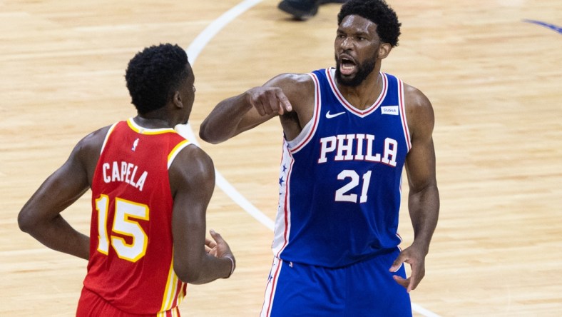 Jun 16, 2021; Philadelphia, Pennsylvania, USA; Philadelphia 76ers center Joel Embiid (21) reacts against Atlanta Hawks center Clint Capela (15) after a guard Ben Simmons (not pictured) dunk during the first quarter in game five of the second round of the 2021 NBA Playoffs at Wells Fargo Center. Mandatory Credit: Bill Streicher-USA TODAY Sports