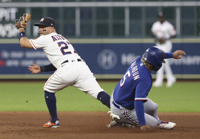 Jun 16, 2021; Houston, Texas, USA; Texas Rangers left fielder Willie Calhoun (5) is forced out at second base by Houston Astros second baseman Jose Altuve (27 in the fifth inning at Minute Maid Park. Mandatory Credit: Thomas Shea-USA TODAY Sports