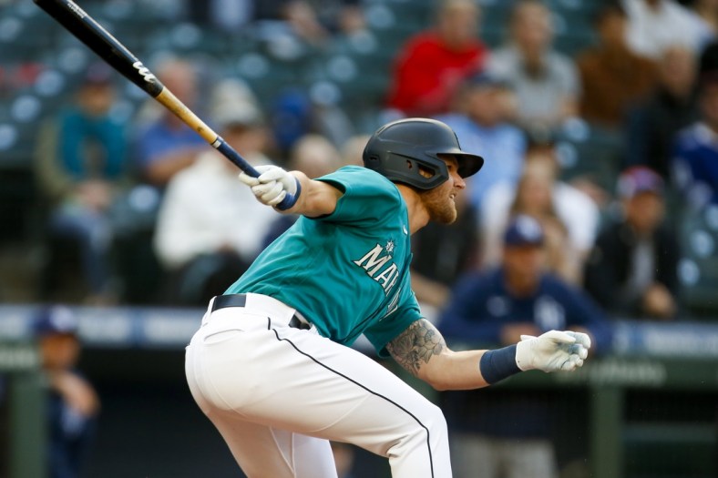 Jun 18, 2021; Seattle, Washington, USA; Seattle Mariners first baseman Jake Bauers (5) hits an RBI single against the Tampa Bay Rays during the first inning at T-Mobile Park. Mandatory Credit: Joe Nicholson-USA TODAY Sports