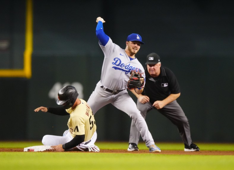 Jun 18, 2021; Phoenix, Arizona, USA; Los Angeles Dodgers shortstop Gavin Lux throws to first after forcing out sliding Arizona Diamondbacks base runner Christian Walker in the fourth inning at Chase Field. Mandatory Credit: Mark J. Rebilas-USA TODAY Sports