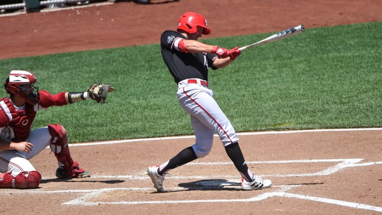 Jun 19, 2021; Omaha, Nebraska, USA;  NC State Wolfpack outfielder Jonny Butler (14) singles in two runs in the fourth inning against the Stanford Cardinal at TD Ameritrade Park. Mandatory Credit: Steven Branscombe-USA TODAY Sports