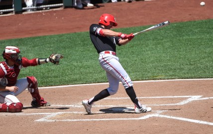 Jun 19, 2021; Omaha, Nebraska, USA;  NC State Wolfpack outfielder Jonny Butler (14) singles in two runs in the fourth inning against the Stanford Cardinal at TD Ameritrade Park. Mandatory Credit: Steven Branscombe-USA TODAY Sports