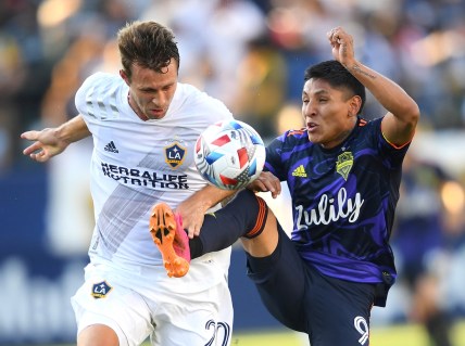 Jun 19, 2021; Carson, California, USA;  Los Angeles Galaxy forward Nick DePuy (20) and Seattle Sounders forward Raul Ruidiaz (9) battle for the ball in the first half at Dignity Health Sports Park. Mandatory Credit: Jayne Kamin-Oncea-USA TODAY Sports