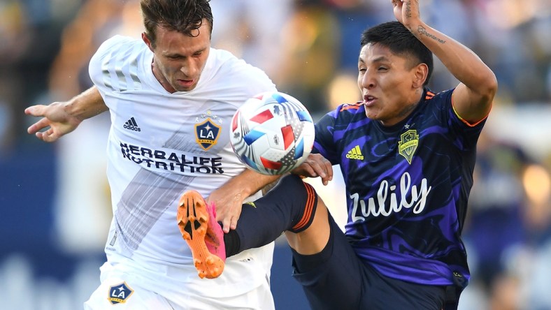 Jun 19, 2021; Carson, California, USA;  Los Angeles Galaxy forward Nick DePuy (20) and Seattle Sounders forward Raul Ruidiaz (9) battle for the ball in the first half at Dignity Health Sports Park. Mandatory Credit: Jayne Kamin-Oncea-USA TODAY Sports