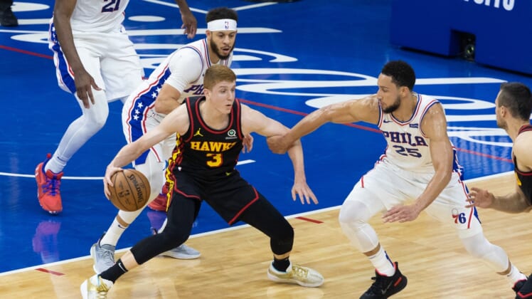 Jun 20, 2021; Philadelphia, Pennsylvania, USA; Atlanta Hawks guard Kevin Huerter (3) controls the ball against Philadelphia 76ers guard Ben Simmons (25) and guard Seth Curry (31) during the second quarter of game seven of the second round of the 2021 NBA Playoffs at Wells Fargo Center. Mandatory Credit: Bill Streicher-USA TODAY Sports