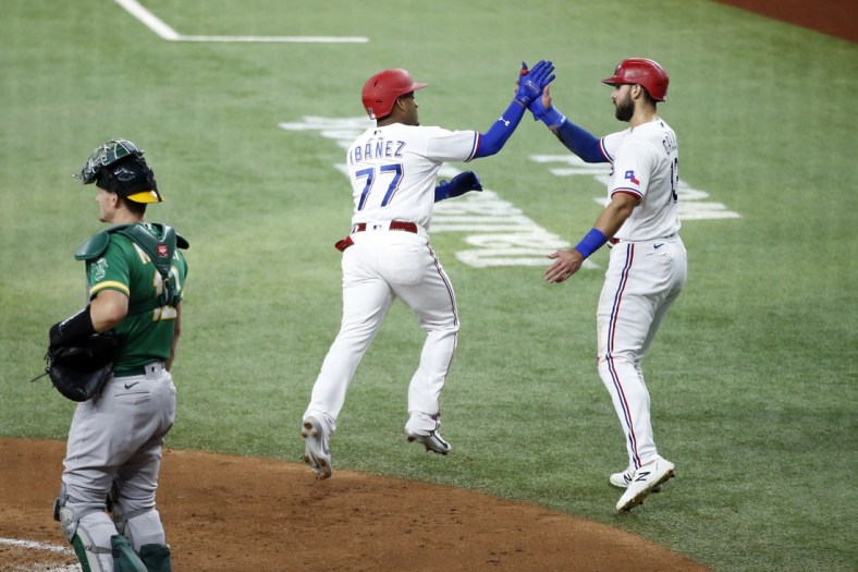 Jun 21, 2021; Arlington, Texas, USA; Texas Rangers second baseman Andy Ibanez (77) is congratulated by right fielder Joey Gallo (13) after hitting a three run home run in the first inning against the Oakland Athletics at Globe Life Field. Mandatory Credit: Tim Heitman-USA TODAY Sports